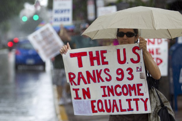 caption: Protesters march in the heavy rain in downtown Fort Lauderdale, Fla.